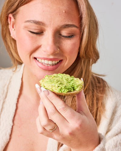 Woman Enjoying Gluten Free Bagel with Avocado