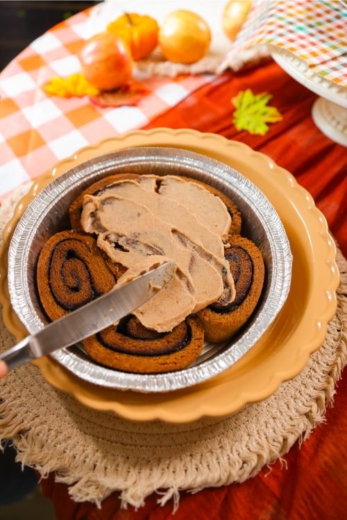 Cinnamon rolls with Maple Pecan frosting on a decorative plate.
