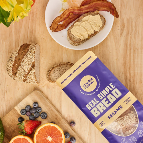 Bag of gluten free bread on table with breakfast plate and fresh fruit on a board