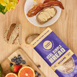 Bag of gluten free bread on table with breakfast plate and fresh fruit on a board